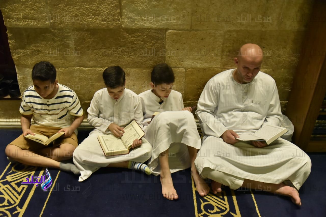 أطفال ووالدهم يقرأون القرآن