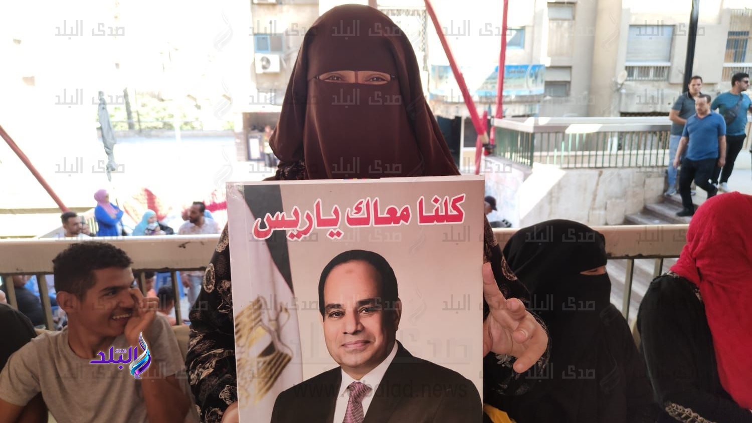 مواطنة تحمل صورة الرئيس