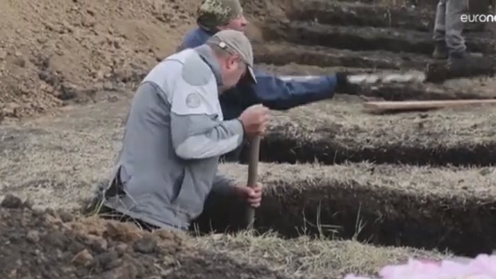 حفر اوكرانيون لمقابر لدفن ضحاياهم جراء القصف الروسي .