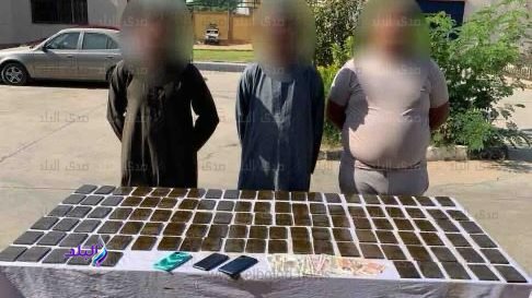 ٣ من المتهمين وامامهم جانب من المضبوطات