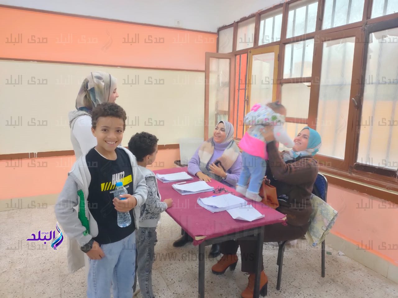 الأطفال يتوافدون مع أمهاتهم على صناديق الاقتراع بالشروق.. وأعضاء اللجنة يحتفون بهم1