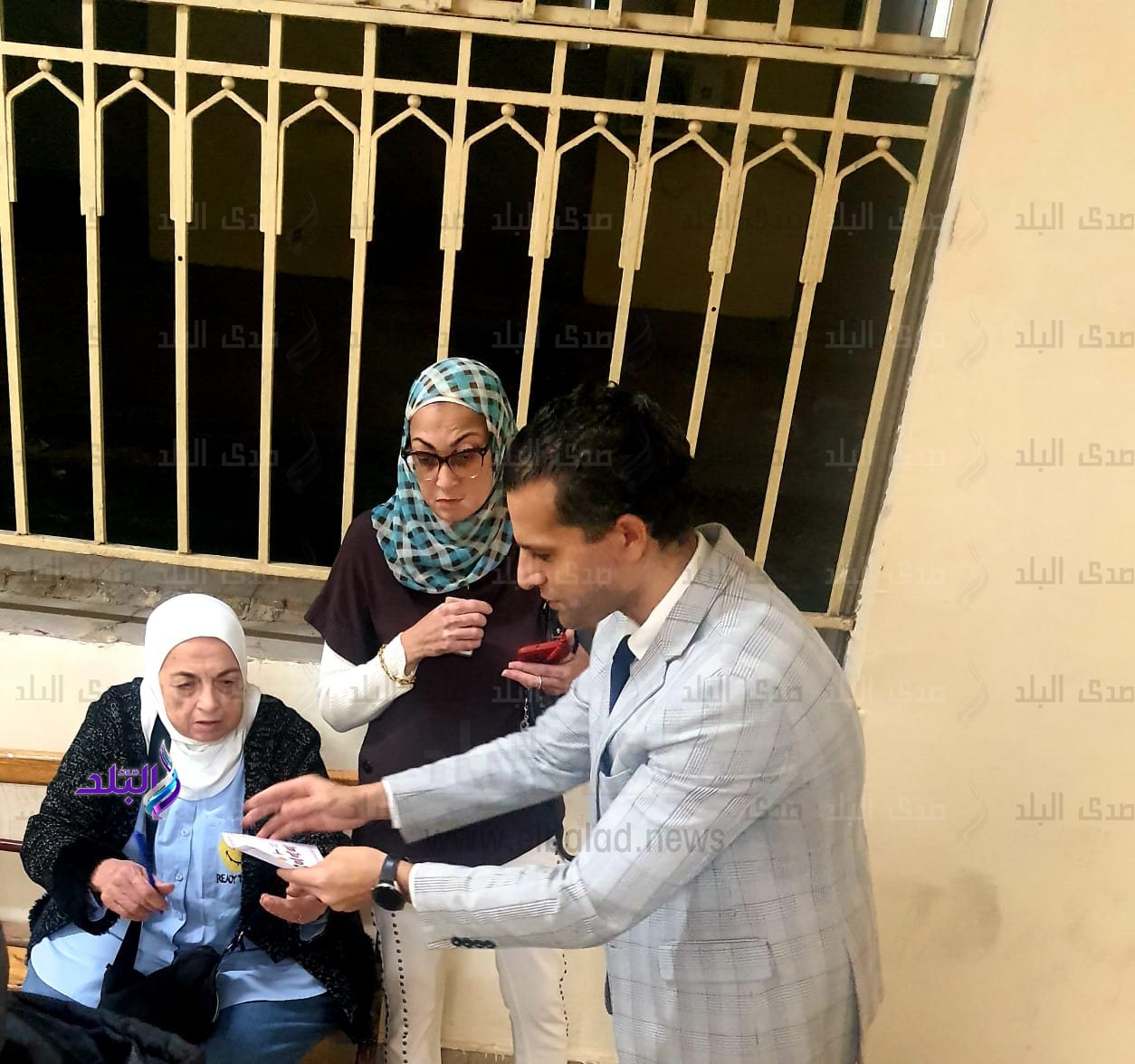 قاضي يساعد ناخبة مسنة على الادلاء بصوتها