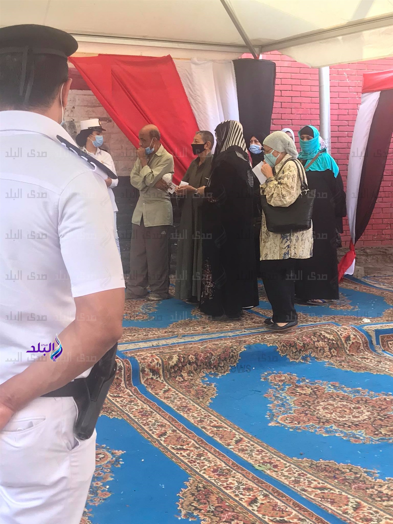 الأمن يساعد كبار السن ويوزع كمامات على الناخبين