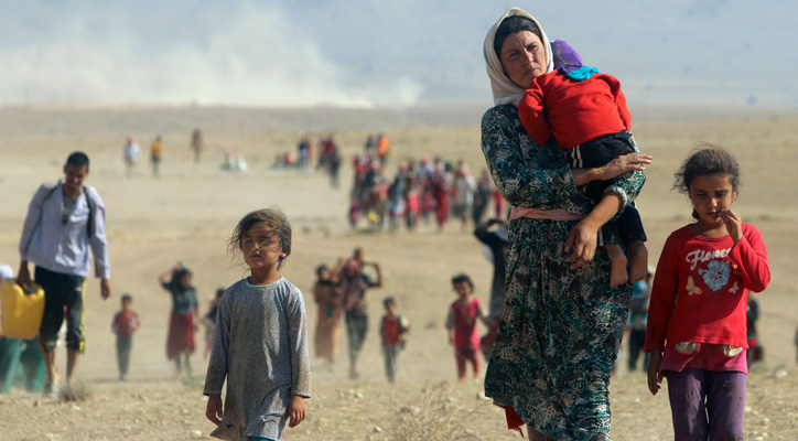 صورة للاجئة تحمل طفلها فارة من ويلات الحروب 
