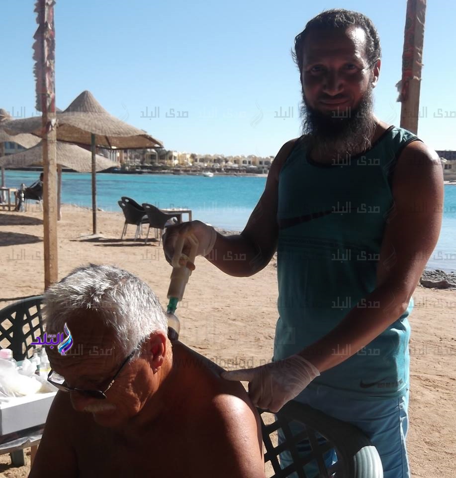 سائح يخضع لجلسة حجامة على شاطئ البحر بالغردقة سائح يخضع لجلسة حجامة على شاطئ البحر بالغردقة