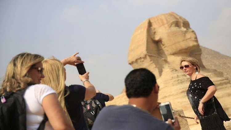 سائحة تلتقط صورة امام ابو الهول