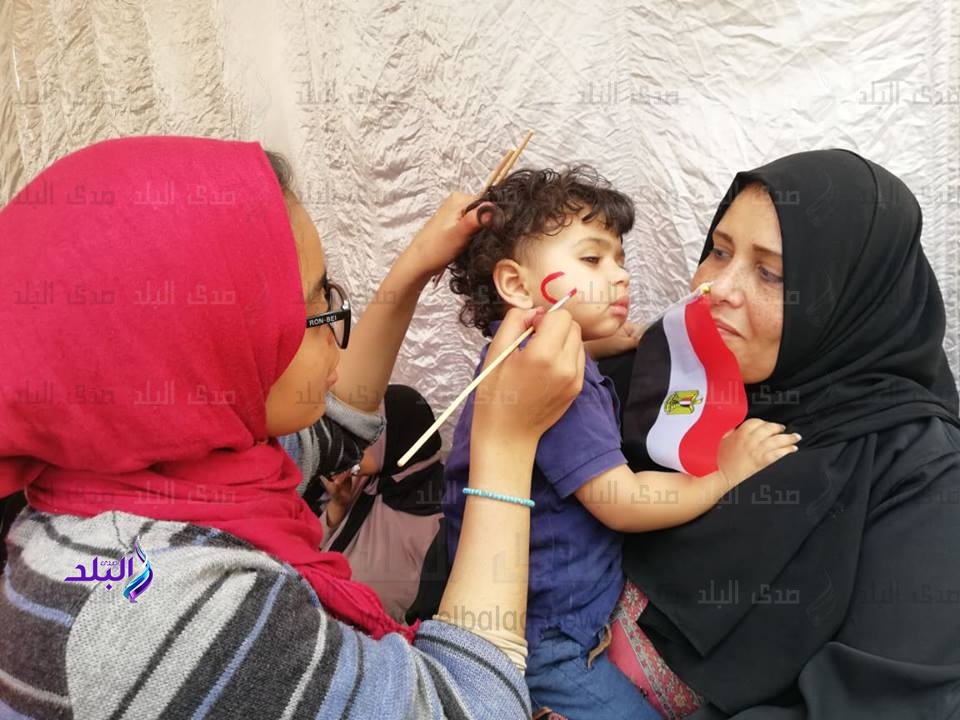 طالبة ترسم علم مصر على وجوه الأطفال