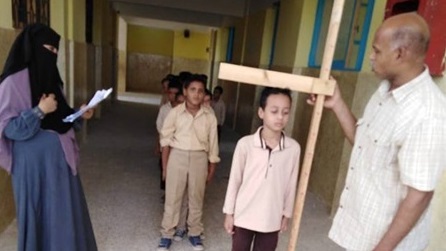 مدير مدرسة يقيس أطوال التلاميذ