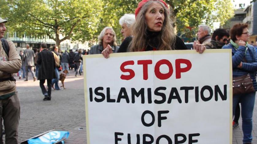 امرأة تحمل لافتة تطالب بوقف الإسلاموفوبيا