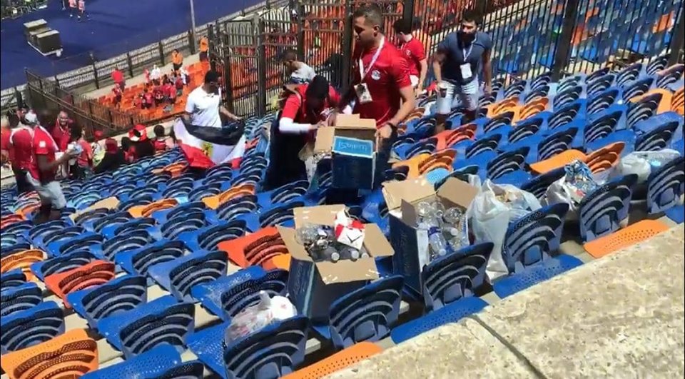 شباب ينظفون مقاعدهم باستاد القاهرة الدولي 