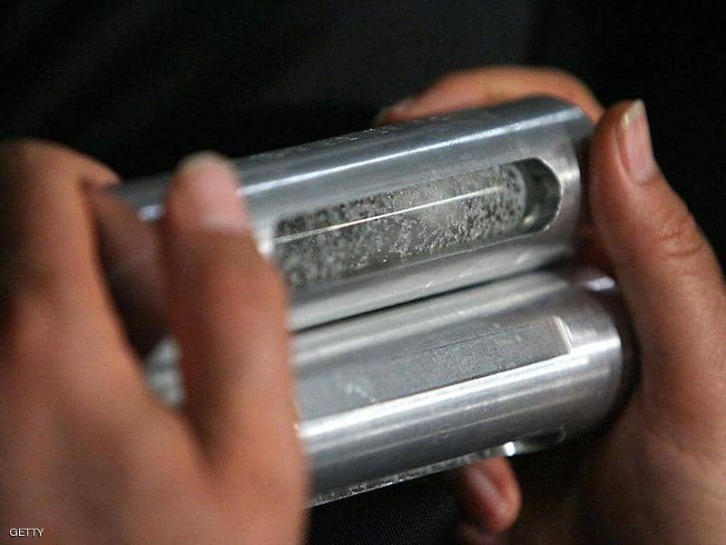 مسؤول إيراني يحمل عينات من اليورانيوم المخصّب