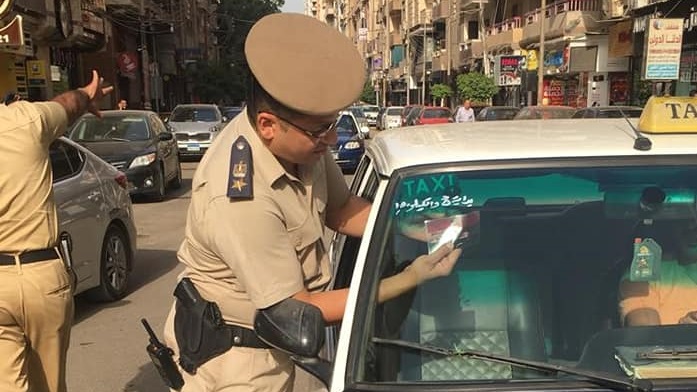 مدير الامن اثناء وضع الملصق مدير الامن اثناء وضع الملصق