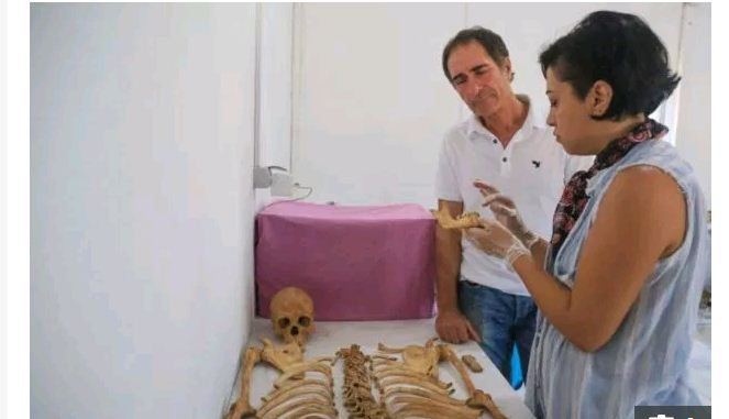 علماء آثار بجوار هيكل عظمي مكتشف علماء آثار بجوار هيكل عظمي مكتشف