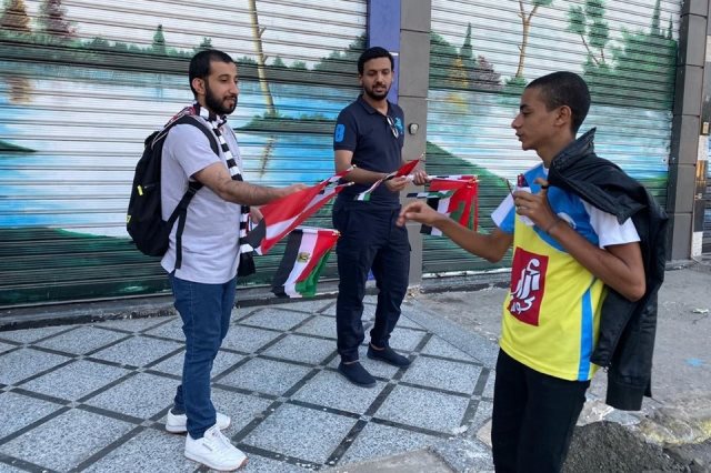 شباب الإمارات يوزعون أعلام مصر خارج استاد الإسماعيلية