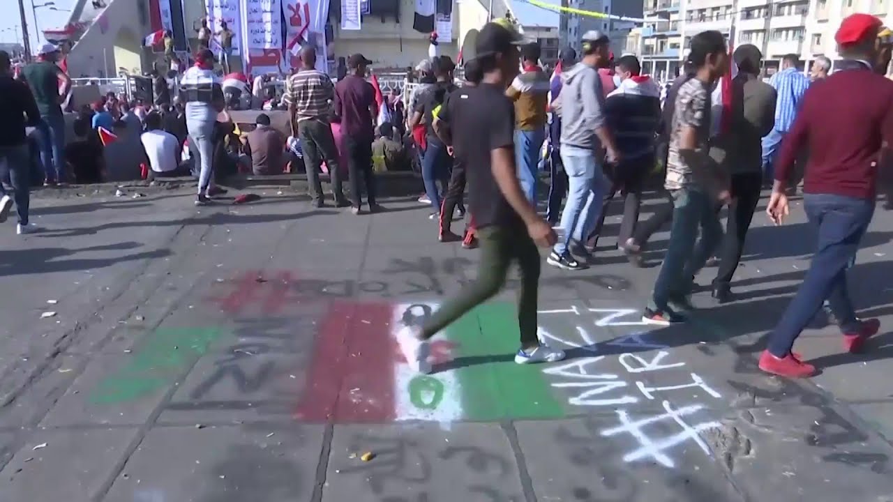 متظاهرون عراقيون يدوسون علم إيران بشعار النازية