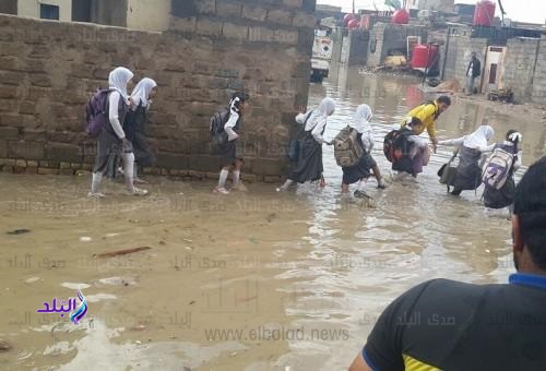 طلاب المدارس يواجهون الأمطار