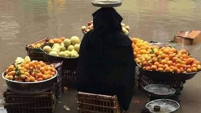 صورة متداولة لبائعة فاكهة خلال الأمطار الغزيرة