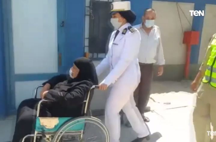 ضابطه تساعد إحدى الناخبات من كبار السن على الادلاء بصوتها 