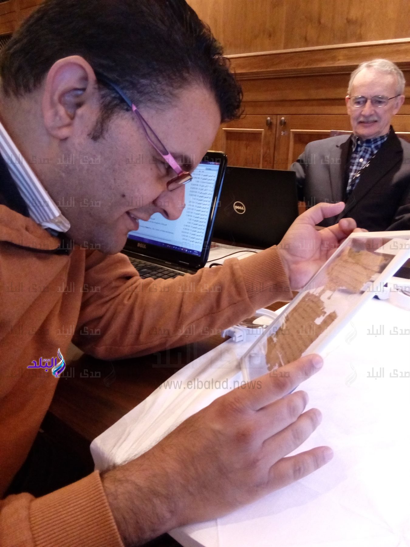 د. إبراهيم ساويرس يفحص شذرة صعيدية في مكتب مايك هولمز