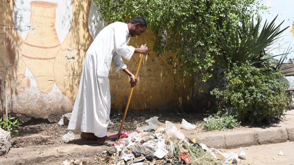 مواطن ينظف الشوارع متطوعاً في قنا