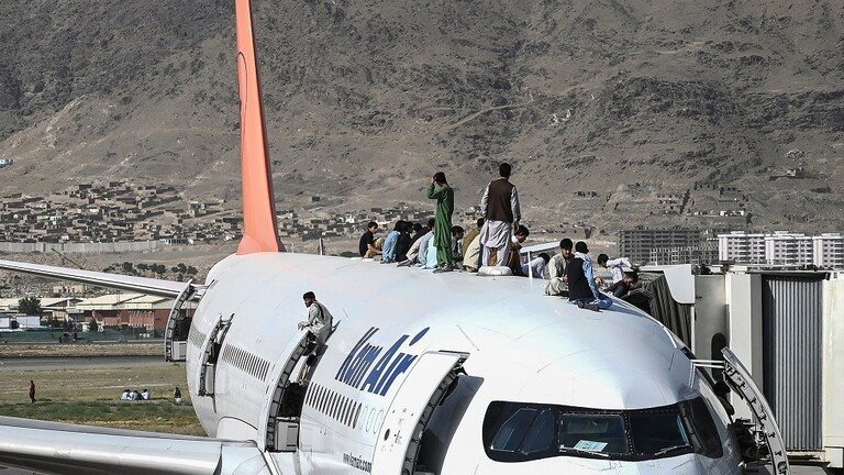 أفغان فوق إحدى الطائرات في فوضى المطار