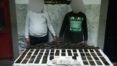 المتهمان وامامهما المضبوطات 