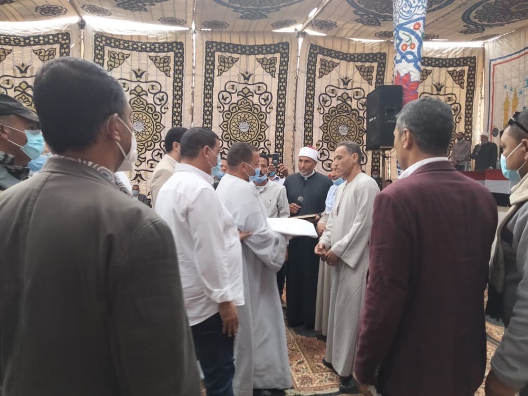 نجل المجنى عليها أثناء أستلامه الكفن من أسرة القتلة