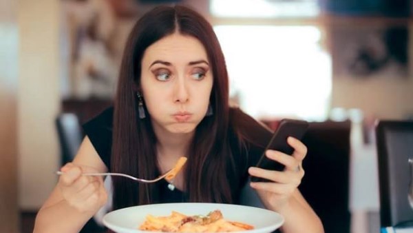 تأثيرات صحية لتناول الطعام أثناء استخدام الهاتف