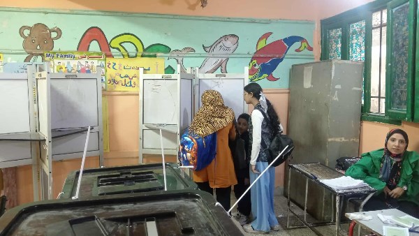 سيدة تصطحب طفليها خلال التصويت 