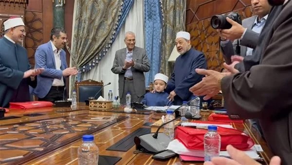شيخ الأزهر يكرم طفلا ويجلسه على كرسيه ويستمع إليه واقفا