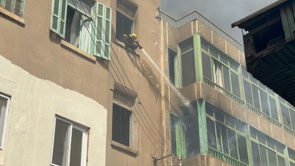 من أعلى العقارات المجاورة.. محاولات لإخماد حريق عقار مصر الجديدة