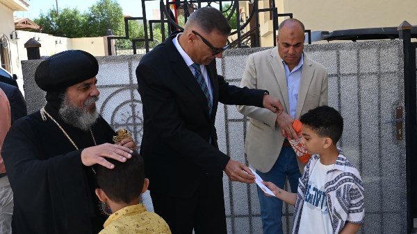 المحافظ خلال توزيعة العيديات علي الأطفال في الكنيسة 