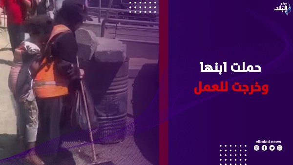 عاملة نظافة تحمل ابنها على ظهرها